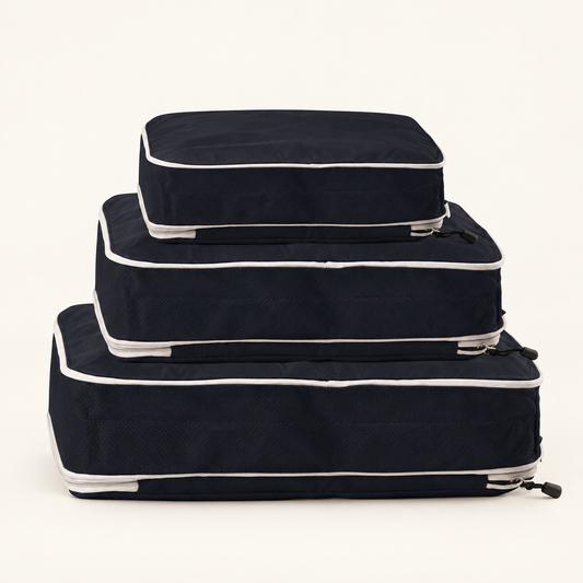 Styled image of the three black compression packing cubes with light gray zippers.